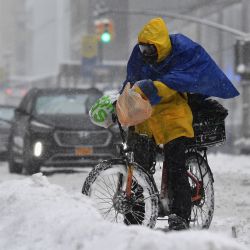 Una persona en una bicicleta de reparto viaja durante una tormenta de invierno en la ciudad de Nueva York. | Foto:Angela Weiss / AFP