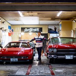 Esta foto muestra a Hiroyuki Wada, que dirige una empresa de servicios de automóviles antiguos, posando para una foto con un Ferrari 328 GTB (L) de 1987 y un Cadillac Coupe DeVille (R) de 1959 después de una entrevista con AFP en su garaje. en Matsudo, Prefectura de Chiba. | Foto:Philip Fong / AFP