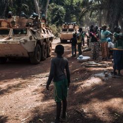 Familias desplazadas del conflicto ven pasar un convoy de fuerzas de paz marroquíes de la Misión de Estabilización Multidimensional Integrada de las Naciones Unidas en la República Centroafricana (MINUSCA) en las afueras de Bangassou. | Foto:Alexis Huguet / AFP
