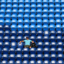 Un fan se sienta entre los asientos vacíos de los espectadores en las gradas mientras el japonés Yoshihito Nishioka juega contra el argentino Guido Pella durante el partido de tenis individual masculino del grupo D de la Copa ATP en Melbourne. | Foto:William West / AFP