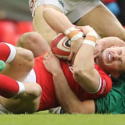 El ala de Gales Hallam Amos (abajo) es atacado por el hooker irlandés Rob Herring durante el partido de rugby de las Seis Naciones entre Gales e Irlanda en el Principality Stadium de Cardiff, Gales del Sur. | Foto:Geoff Caddick / AFP