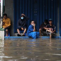 Los residentes se sientan afuera de su casa inundada en Yakarta, mientras las fuertes lluvias inundaron áreas junto a los ríos de la ciudad. | Foto:Dasril Roszandi / AFP