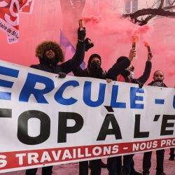 Los manifestantes sostienen bengalas y una pancarta que dice  | Foto:Alain Jocard / AFP
