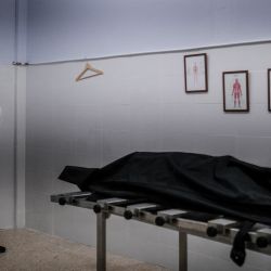 Un trabajador funerario con traje de protección se encuentra junto al cuerpo de una víctima del Covid-19 en una funeraria en Amadora, en las afueras de Lisboa. | Foto:Patricia De Melo Moreira / AFP