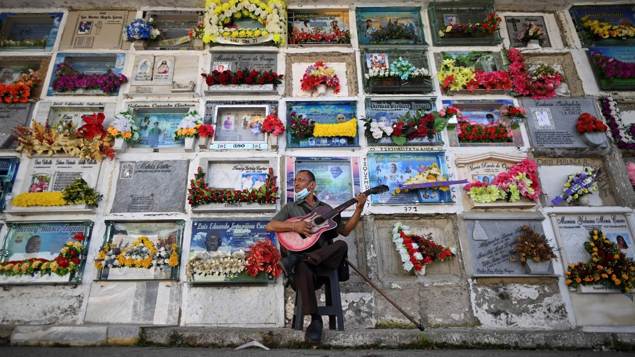 Javier Giraldo, de 57 años, músico que ha tocado su guitarra durante 30 años en entierros, es visto en el cementerio de Buenaventura, Colombia. | Foto:Luis Robayo / AFP