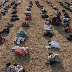 Una persona desplazada, que huye de la violencia en la zona de Metekel en el oeste de Etiopía, se sienta entre pilas de ropa que se distribuye en un campamento en Chagni, Etiopía. | Foto:Eduardo Soteras / AFP