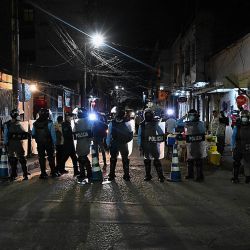 Policías antidisturbios bloquean una calle mientras al menos nueve policías acusados de estar involucrados en la muerte de un estudiante de enfermería, abandonan la sede de Medicina Forense en Tegucigalpa.- Keyla Martínez, de 26 años, falleció en una celda de la Policía Nacional. luego de ser capturado en el municipio de La Esperanza por violar un toque de queda impuesto por el gobierno en medio de la pandemia de COVID-19. | Foto:Orlando Sierra / AFP