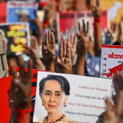 Los manifestantes levantan el saludo de tres dedos con carteles pidiendo la liberación del líder civil de Myanmar detenido Aung San Suu Kyi durante una manifestación contra el golpe militar en Yangon. | Foto:Ye Aung Thu / AFP