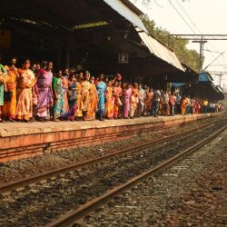 Pasajeros varados esperan su tren mientras estudiantes de izquierda junto con otros bloquean el servicio de ferrocarril suburbano para protestar contra las recientes reformas agrícolas del gobierno central, la brutalidad policial en Bengala Occidental y el aumento del precio de la gasolina, en Calcuta. | Foto:Dibyangshu Sarkar / AFP