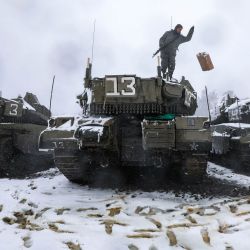 Un soldado israelí lanza un bidón mientras está parado sobre un tanque de batalla Merkava Mark IV estacionado con otros cerca de Moshav Alonei HaBashan en los Altos del Golán anexados por Israel. | Foto:Jalaa Marey / AFP