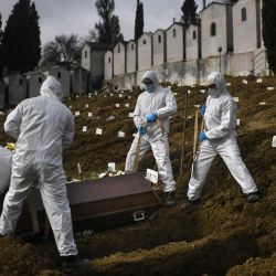 Los excavadores de tumbas con trajes protectores entierran a una víctima de Covid-19 en el cementerio Alto de Sao Joao en Lisboa. | Foto:Patricia De Melo Moreira / AFP