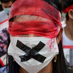 Un manifestante usa una máscara y una venda en los ojos mientras los migrantes de Myanmar en Tailandia se manifiestan contra el golpe militar en su país de origen. AFP | Foto:AFP