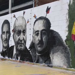 El artista callejero español RocBlackBlock trabaja en su nueva pintura mural que representa los retratos del rey Felipe VI de España (L), su padre, el ex rey Juan Carlos (C) y el dictador español Francisco Franco, en Barcelona. AFP | Foto:AFP