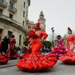Mujeres vestidas con trajes de flamenca marchan durante una protesta para esclarecer las dificultades que enfrenta el sector de la moda flamenca por las restricciones del coronavirus, en Sevilla. | Foto:AFP