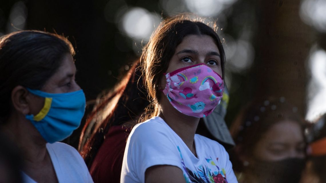 A girl along with other people participates in a religious event in memory of two young women murdered days ago in the town of La Mision in the state of Portuguesa, Venezuela on February 27, 2021.