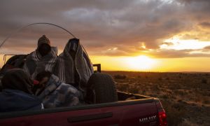 Venezuelan migrant Rubi Alexander G. (right) and friends travel in the back of a truck along Route 15, after crossing from Bolivia, in Huara, Chile, on February 17, 2021. Crossing the highlands of the border between Bolivia and Chile on foot is the hardest part of the journey Venezuelan migrants go through on their way to Iquique or Santiago.