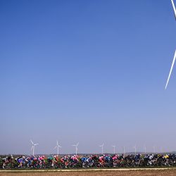 El grupo pasa frente a un parque eólico durante la segunda etapa de la 79a carrera ciclista París - Niza, 188 km entre Oinville-sur-Montcent y Amilly. | Foto:Anne-Christine Poujoulat / AFP