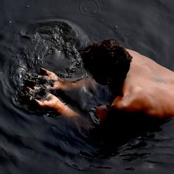Un hombre busca objetos de valor en el río Yamuna contaminado en Nueva Delhi. | Foto:Money Sharma / AFP
