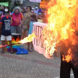 Una mujer quema un letrero que dice  | Foto:Norberto Duarte / AFP