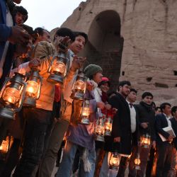 Residente y activista de la sociedad civil sostienen lámparas mientras están cerca del sitio donde una vez estuvo la estatua del Buda Salsal durante una ceremonia de conmemoración del 20 aniversario desde la destrucción de los Budas de Bamiyán por los talibanes en marzo de 2001, en la provincia de Bamiyán. | Foto:Wakil Kohsar / AFP