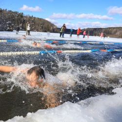 Las personas nadan en una competencia anual de natación de invierno en agua helada, con temperaturas exteriores de menos 2 grados centígrados, en Vilnius, Lituania. | Foto:Petras Malukas / AFP