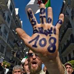 Un manifestante antigubernamental argelino muestra su palma con la inscripción  | Foto:Ryad Kramdi / AFP