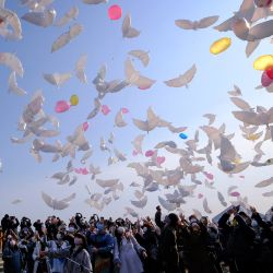Las personas lanzan globos en forma de paloma al cielo para llorar a las víctimas del terremoto y el tsunami en Natori, prefectura de Miyagi, el décimo aniversario del terremoto de magnitud 9,0 que provocó un tsunami y un desastre nuclear que mató a más de 18.000 personas. | Foto:Kazuhiro Nogi / AFP