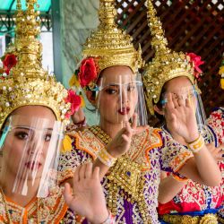 Bailarines tradicionales tailandeses que llevan protectores faciales contra la propagación del coronavirus Covid-19 se presentan en el Santuario de Erawan en Bangkok. | Foto:Mladen Antonov / AFP
