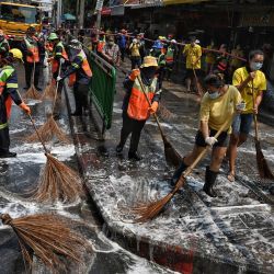 Los trabajadores limpian el exterior del mercado Bang Khae, después de que más de un centenar de residentes en el distrito dieron positivo por el coronavirus Covid-19, en Bangkok. | Foto:Lillian Suwanrumphia / AFP