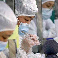 Los empleados fabrican chips en una fábrica de Jiejie Semiconductor Company en Nantong, en la provincia de Jiangsu, en el este de China. | Foto:STR / AFP