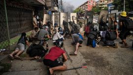 Los manifestantes se protegen detrás de escudos caseros mientras se enfrentan a la policía durante la represión de las manifestaciones contra el golpe militar en Yangon.
