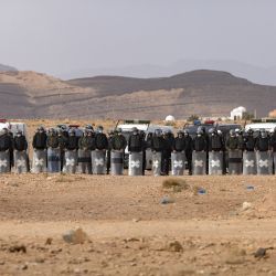 Las fuerzas de seguridad marroquíes montan guardia mientras los agricultores marroquíes protestan en la ciudad de Figuig, después de que las autoridades argelinas expulsaran a los productores de dátiles del territorio argelino, una zona fronteriza a la que tradicionalmente están autorizados a cultivar. | Foto:Fadel Senna / AFP