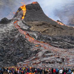 Los excursionistas miran la lava que fluye del volcán Fagradalsfjall en erupción a unos 40 km al oeste de la capital islandesa. | Foto:Jeremie Richard / AFP