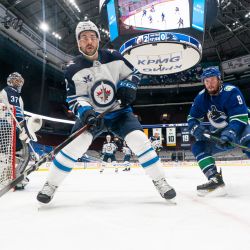 Dylan DeMelo de los Winnipeg Jets y JT Miller de los Vancouver Canucks patinan hacia las tablas para recuperar un disco suelto durante el tercer período de acción de la NHL en el Rogers Arena en Vancouver. | Foto:Rich Lam / Getty Images / AFP