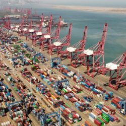 Una fotografía aérea muestra grúas portacontenedores y contenedores en la terminal de contenedores del puerto de Lianyungang en Lianyungang, provincia de Jiangsu. | Foto:Hector Retamal / AFP