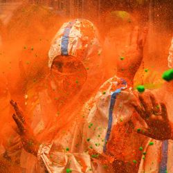 Las personas que usan trajes protectores como medida preventiva contra la propagación del coronavirus Covid-19, juegan con polvos de colores mientras celebran Holi, el festival de colores de primavera durante una oportunidad para tomar fotografías organizada por un club local en Calcuta. | Foto:Dibyangshu Sarkar / AFP