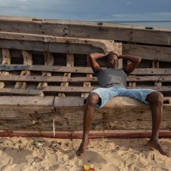 Un hombre espera en un bote en la costa de Paquitequete donde se espera que lleguen veleros con personas desplazadas de las costas de Palma y Afungi luego de sufrir ataques de grupos armados. | Foto:Alfredo Zuniga / AFP