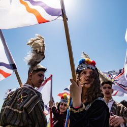 Jóvenes vestidos con trajes tradicionales, izan banderas asirias mientras participan en un desfile anual para conmemorar el año nuevo, también conocido como Akitu, en el campo de la ciudad de Qahtaniya, en la provincia de Hasakeh en Siria. | Foto:Delil Souleiman / AFP