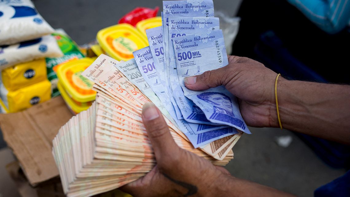 A man holds Bolivar bills a street market in Caracas' Catia neighbourhood, on April 6, 2021, amid the Covid-19 pandemic.