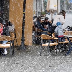 Las personas se sientan afuera en un café durante una lluvia de aguanieve en Saarbruecken, en el oeste de Alemania, cuando el estado fronterizo de Saarland reabrió parcialmente durante la pandemia de coronavirus (Covid-19) en curso. | Foto:Jean-Christophe Verhaegen / AFP
