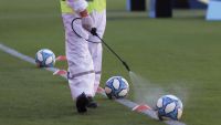1004- person disinfecting a football ball