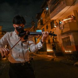 Un hombre toca el violín durante un homenaje en honor a las 4008 muertes registradas por Coronavirus, en Medellín, Colombia. | Foto:Joaquin Sarmiento / AFP