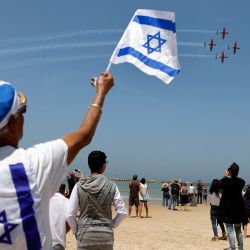 Israelíes ven los aviones Efroni T-6 Texan II actuar sobre la ciudad costera mediterránea de Tel Aviv durante las celebraciones que marcan el 73 ° Día de la Independencia de Israel. | Foto:Jack Guez / AFP