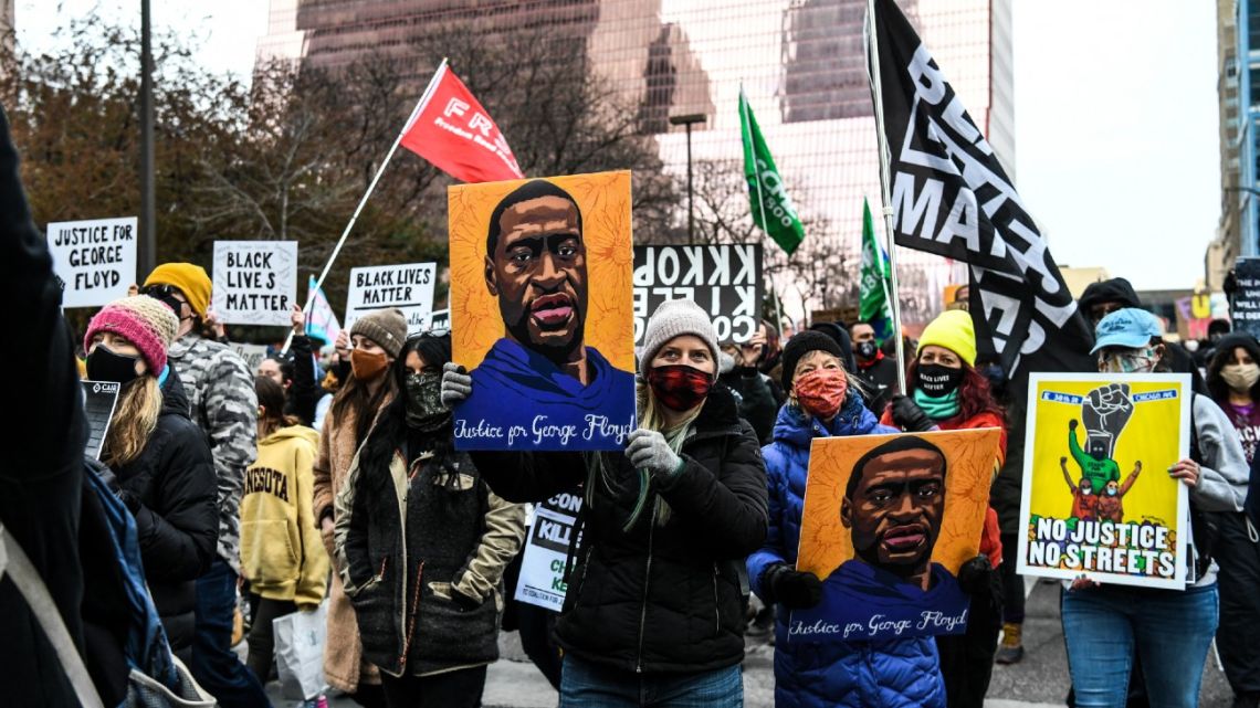 People hold placards as they protest outside of the Courthouse during the trial of former Minneapolis police officer charged with murdering George Floyd in Minneapolis, Minnesota on April 19, 2021. Jurors on Monday began mulling the fate of the white ex-Minneapolis policeman accused of killing African-American George Floyd, a death that sparked a nationwide reckoning on racism and which prosecutors called a "shocking abuse of authority".