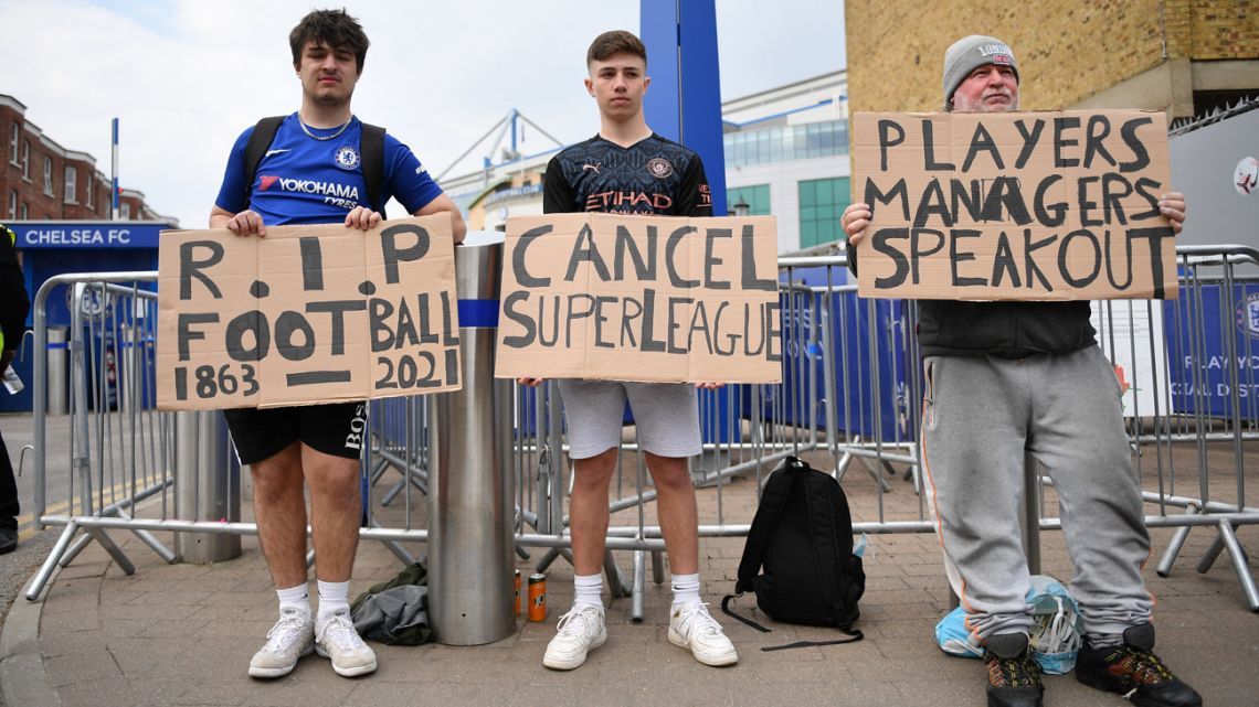 A group of supporters hold up placards critical of the idea of a new European Super League, outside English Premier League club Chelsea's Stamford Bridge stadium in London on April 20, 2021, ahead of their game against Brighton. The 14 Premier League clubs not involved in the proposed European Super League "unanimously and vigorously rejected" the plans at an emergency meeting on Tuesday. Liverpool, Arsenal, Chelsea, Manchester City, Manchester United and Tottenham Hotspur are the English clubs involved. 