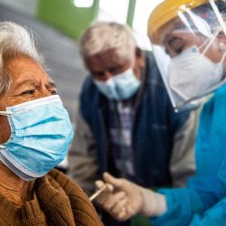 Un trabajador de la salud inocula una dosis de la vacuna Pfizer-BioNTech contra COVID-19 a una persona mayor, en un centro de vacunación en Lima. | Foto:Ernesto Benavides / AFP