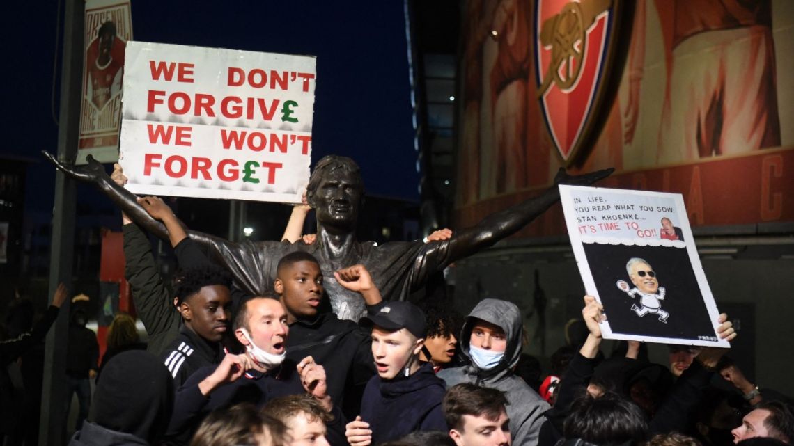 Supporters protest next to the statue of Tony Adams against Arsenal's US owner Stan Kroenke, outside English Premier League club Arsenal's Emirates stadium in London on April 23, 2021, ahead of their game against Everton. Arsenal were one of six Premier League teams to sign up to the breakaway tournament on Sunday. But just 48 hours later the Super League collapsed as Arsenal and the rest of the English clubs pulled out.  