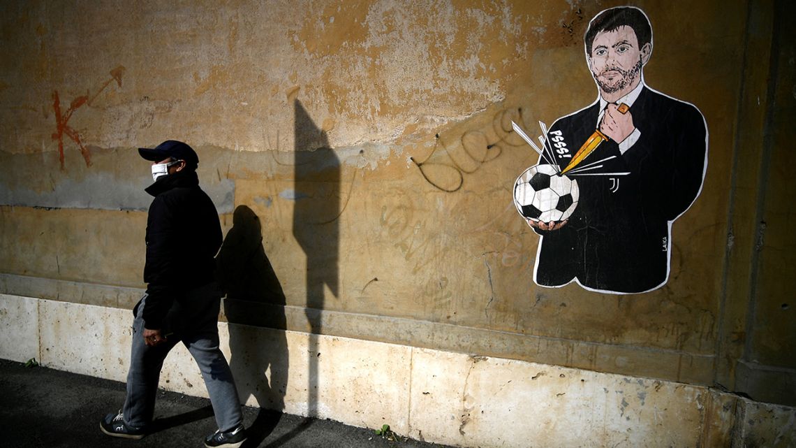 A man walks past a grafiti entitled 