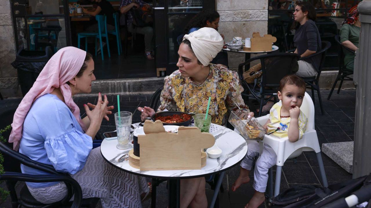 La gente come en la terraza de un restaurante en Jerusalén, después de que las autoridades israelíes anunciaran que las mascarillas para la prevención del COVID-19 ya no eran necesarias al aire libre. - | Foto:AFP
