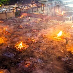 Se ven hombres alrededor de las piras ardientes de las víctimas que perdieron la vida debido al coronavirus Covid-19 en un campo de cremación en Nueva Delhi. | Foto:Jewel Samad / AFP